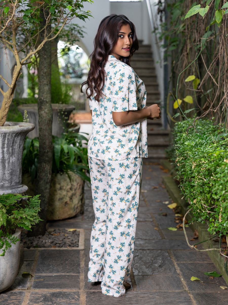 Woman in a floral outfit standing in a garden setting