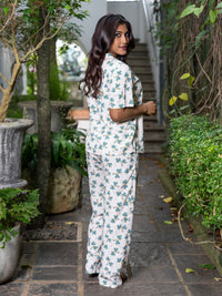 Woman in a floral outfit standing in a garden setting