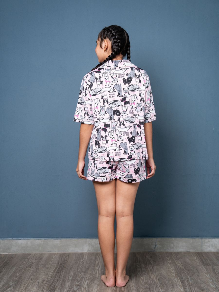 Person wearing a patterned pajama set against a blue wall.