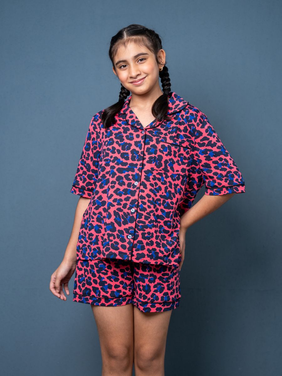 Girl wearing a pink and blue patterned outfit against a gray background