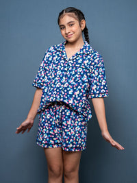 Girl wearing a blue floral pajama set against a gray background