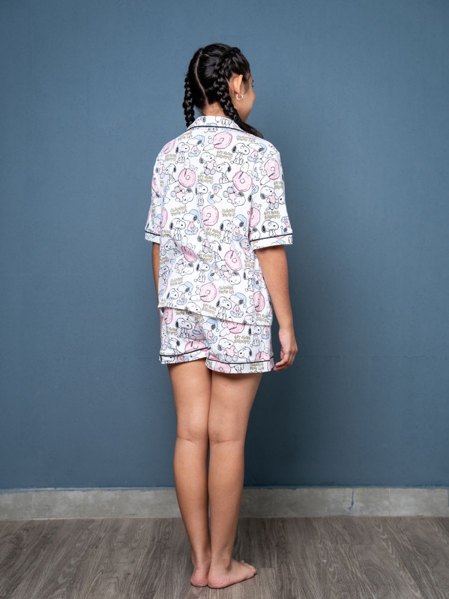 Person wearing a patterned pajama set against a blue wall.