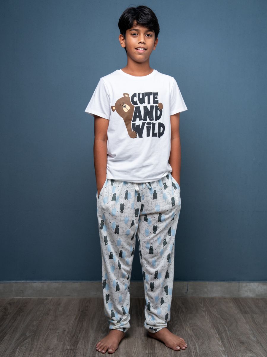 Child wearing a 'Cute and Wild' t-shirt and pajama set against a blue wall.