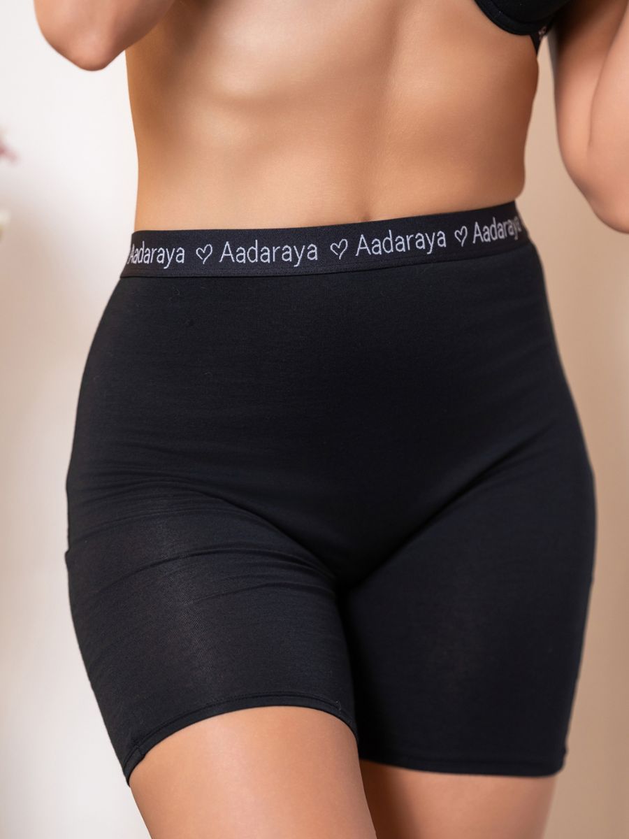 Black shorts with 'Aadaraya' waistband on a neutral background