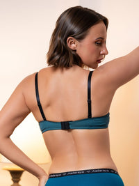 Woman wearing a blue bra and panties set with 'Aadaraya' branding on a beige background