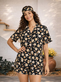 Woman wearing a black floral dress with a matching headband in a casual setting.