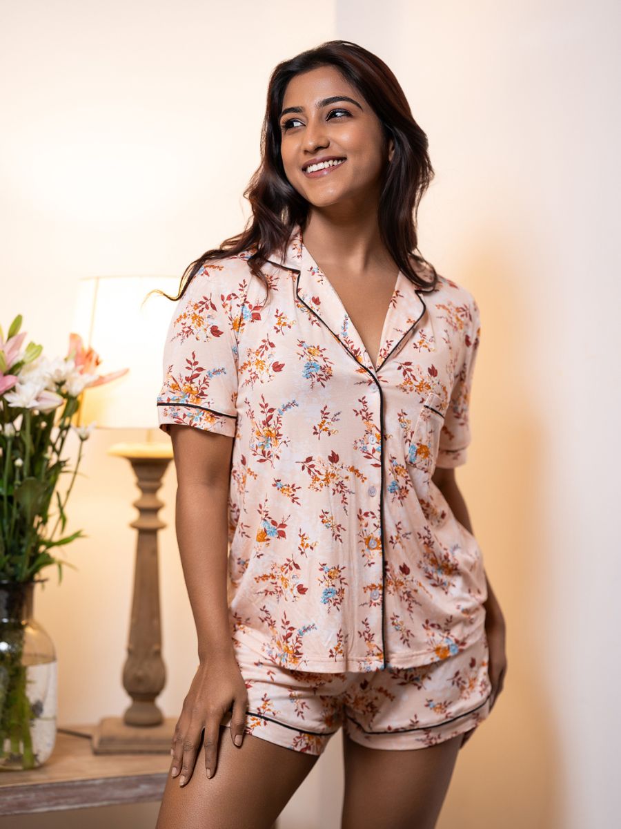 Woman wearing a floral pajama set in a warm indoor setting