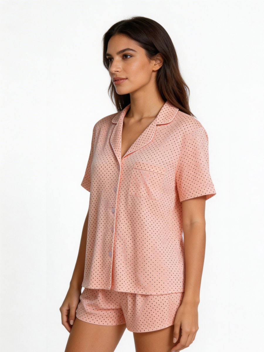 Woman wearing a pink polka dot pajama set on a white background