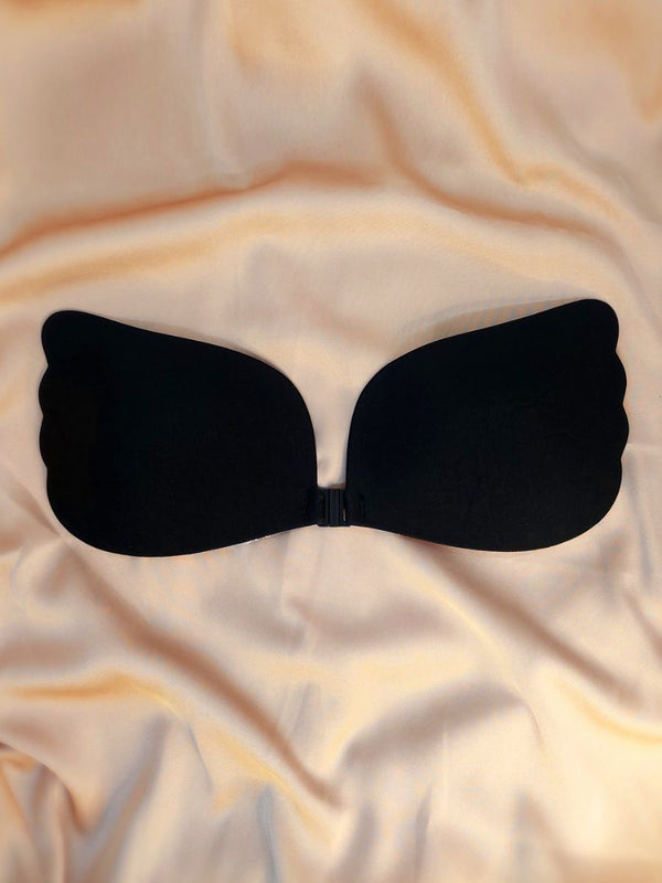 Black strapless bra on a beige fabric background