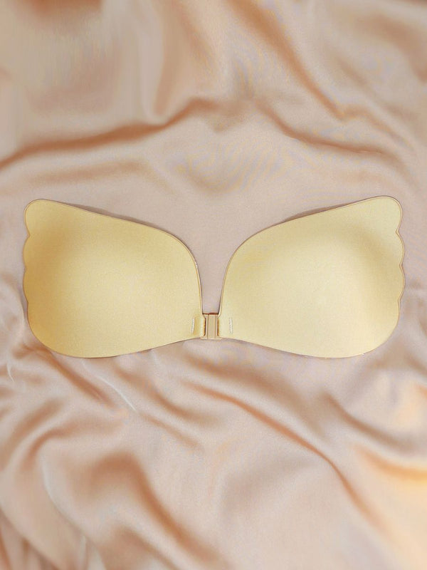 Gold bikini top on a beige fabric background