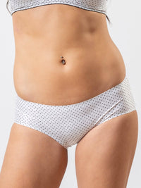 White polka dot underwear worn by a person on a white background