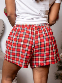 Red plaid shorts worn by a person with a blurred background