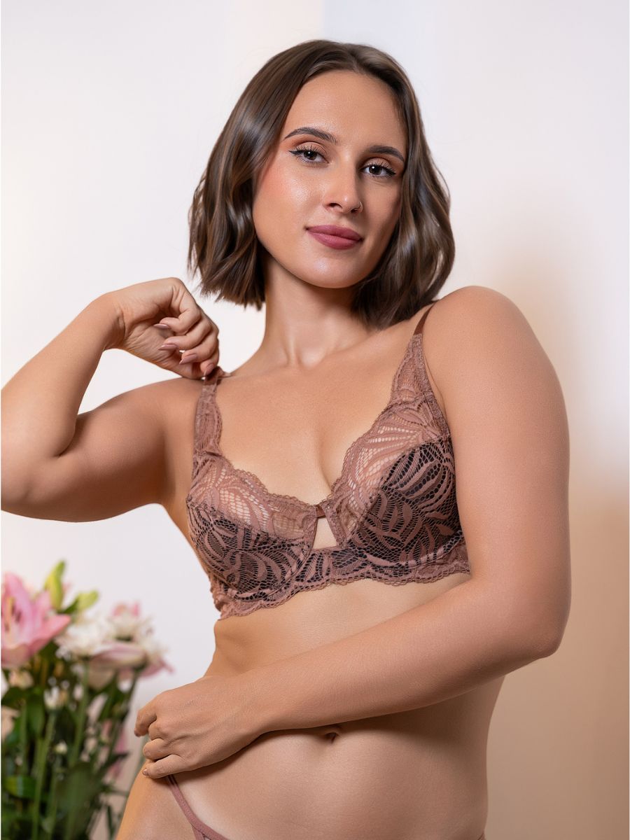 Woman wearing a lace bralette with a neutral background
