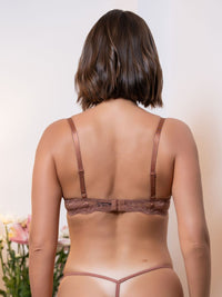 Woman wearing a brown lingerie set against a neutral background