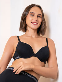 Woman wearing a black Aadaraya bra and underwear set against a white background