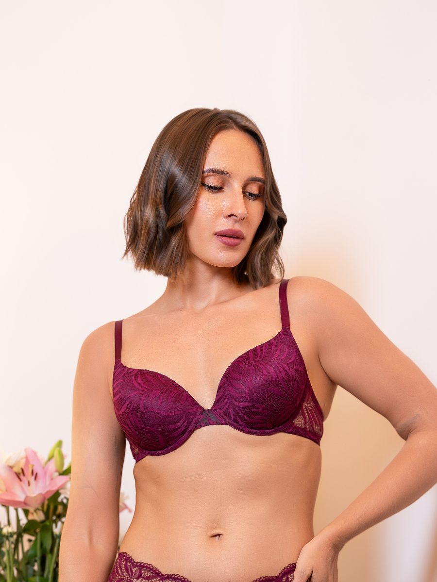 Woman wearing a purple bra against a plain background