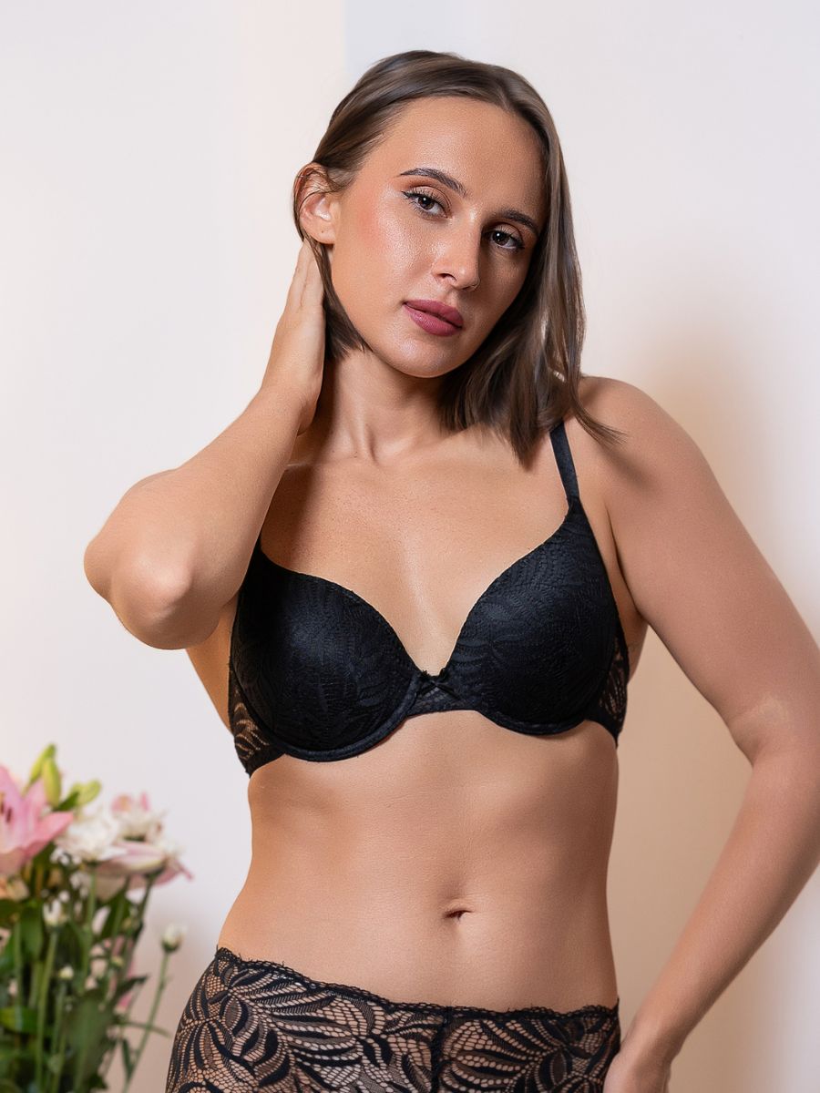 Woman wearing a black bra with a neutral background