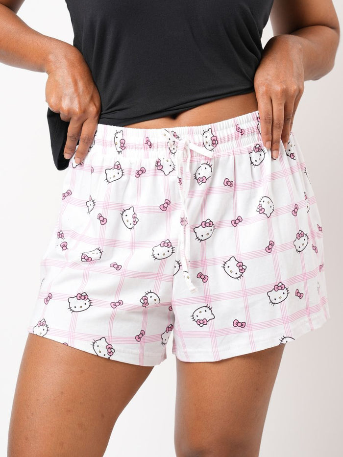 White shorts with Hello Kitty pattern worn by a person on a plain background