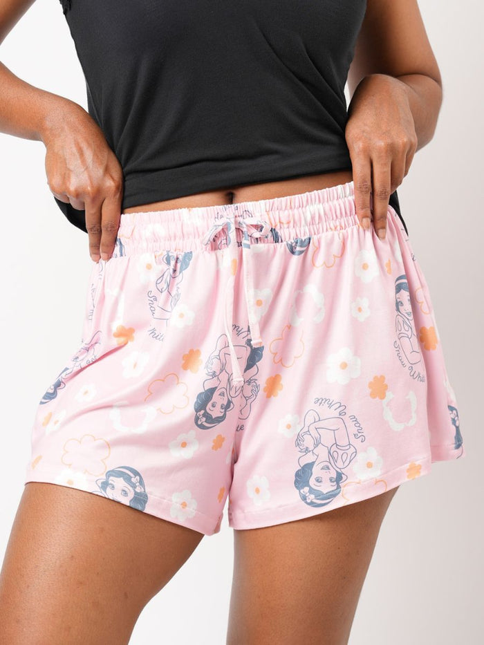 Person wearing pink shorts with cartoon character print on a plain background