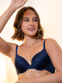 Woman wearing a navy blue bra against a beige background