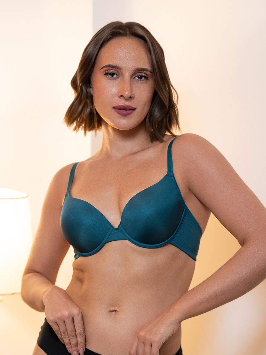 Woman wearing a teal bra against a neutral background
