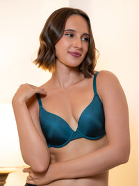 Woman wearing a teal bra against a neutral background