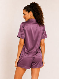 Woman wearing a purple satin outfit on a plain background