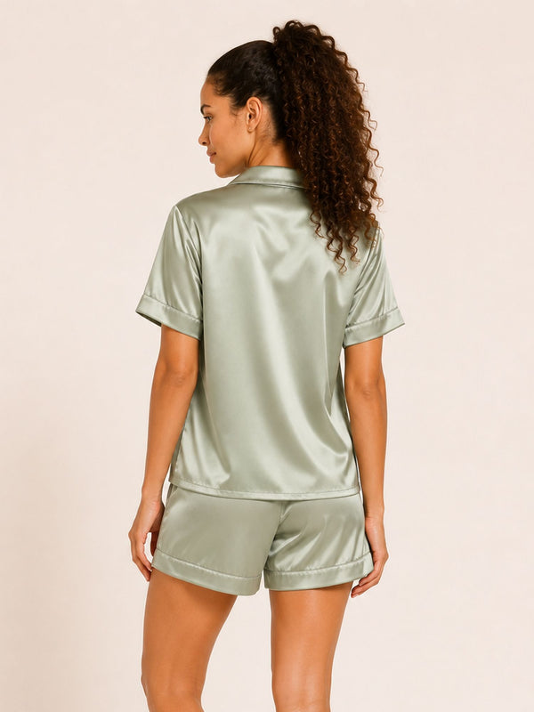 Woman wearing a light green satin pajama set on a beige background