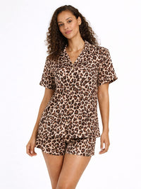 Woman wearing a leopard print pajama set on a white background