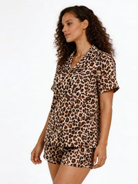 Woman wearing a leopard print pajama set on a white background