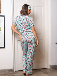 Woman wearing a floral pajama set in a room with a white door.