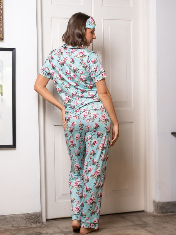Woman wearing a floral pajama set in a room with a white door.