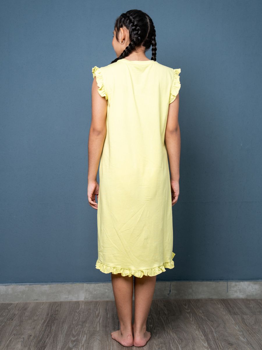 Young girl wearing a yellow dress against a blue wall