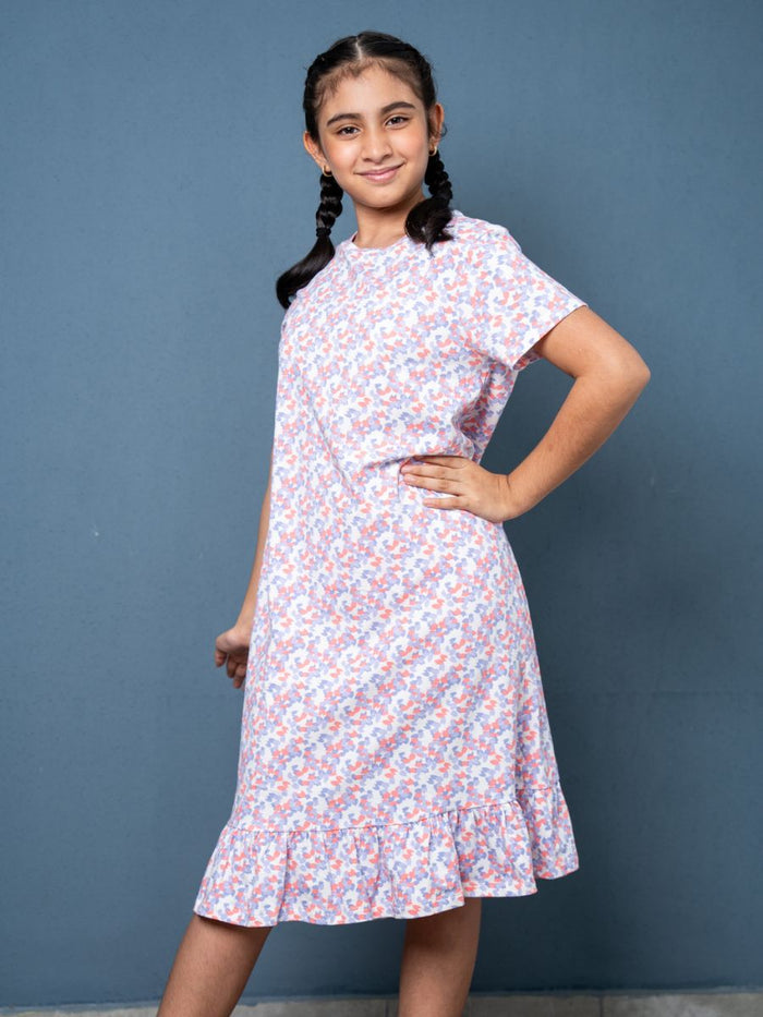 Young girl wearing a floral dress against a blue background