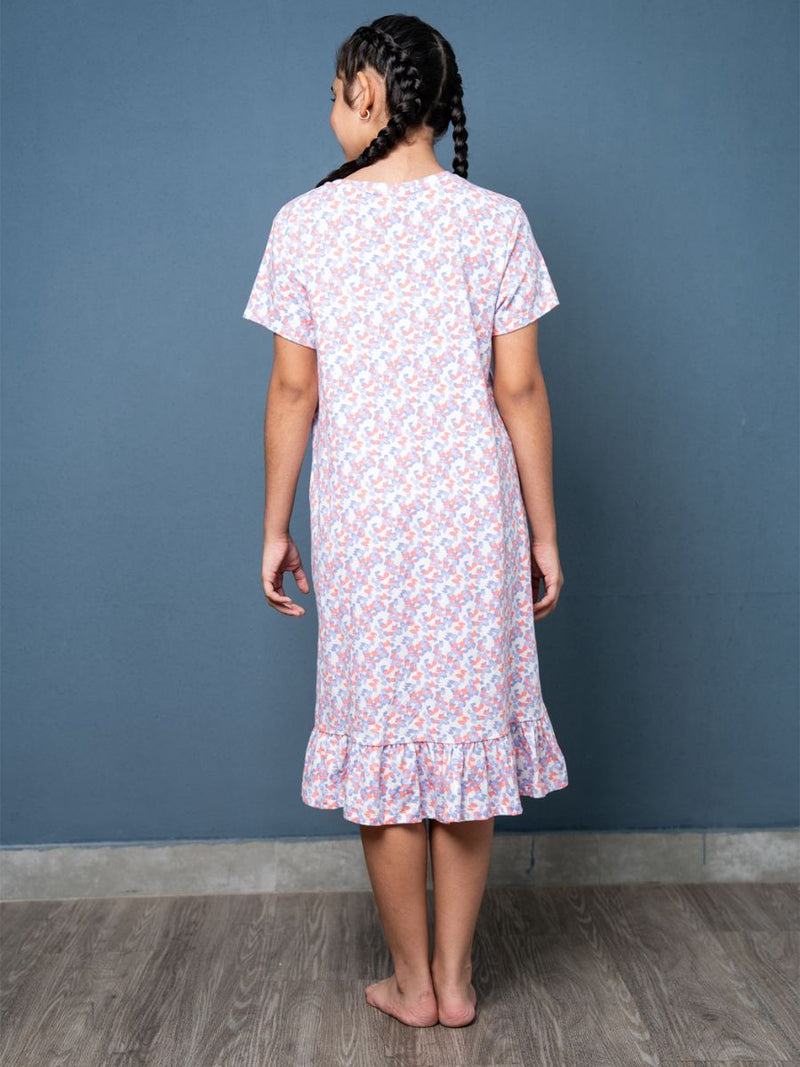 Person wearing a floral dress against a blue wall
