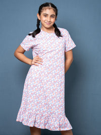 Young girl wearing a floral dress against a blue background