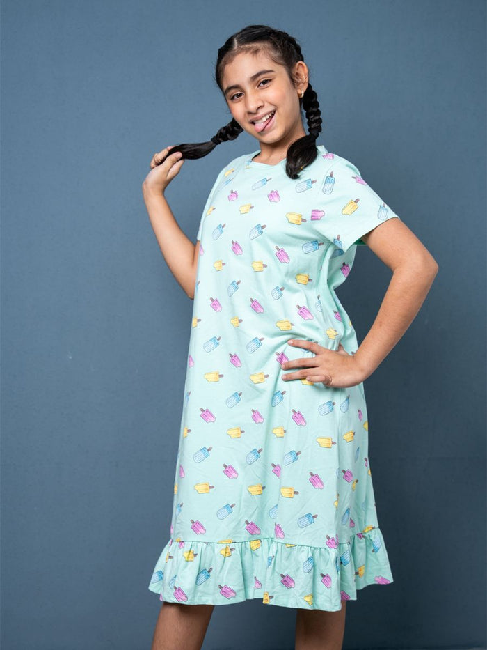 Girl wearing a light blue dress with colorful popsicle pattern 