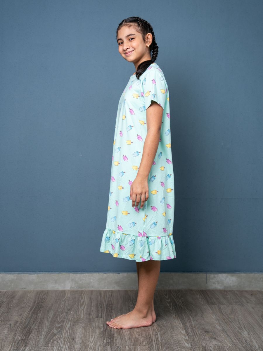 Girl wearing a light blue nightgown with colorful patterns