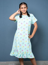 Girl wearing a light blue dress with colorful popsicle pattern against a gray background