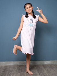 Young girl in a lilac nightgown posing against a blue wall