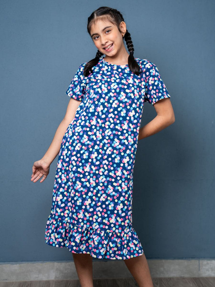 Girl wearing a blue floral dress against a gray background
