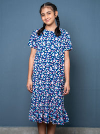 Girl wearing a blue floral dress against a gray background