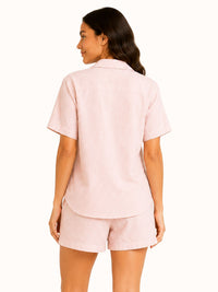 Woman wearing a light pink outfit on a white background