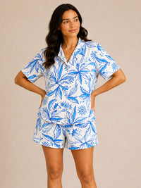 Woman wearing a blue and white floral pajama set on a beige background