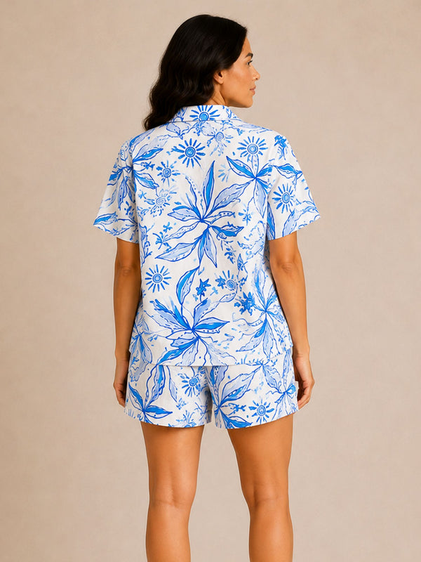 Woman wearing a blue and white floral pajama set on a beige background