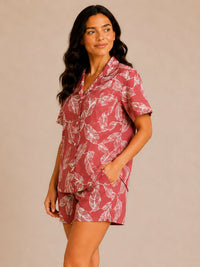 Woman wearing a red and white patterned pajama set against a beige background