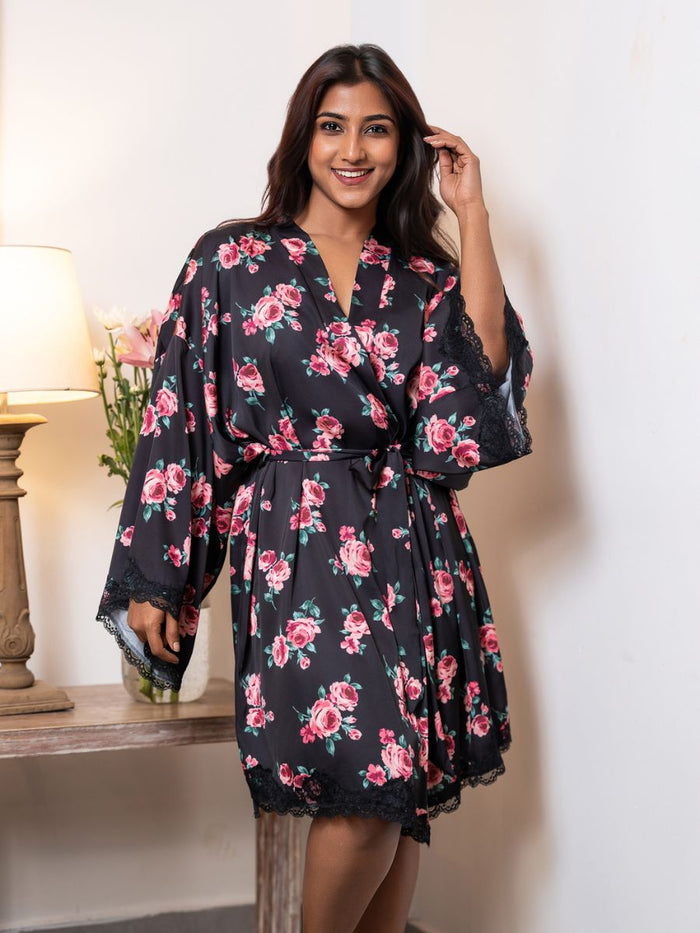 Woman wearing a black floral robe in a room setting.