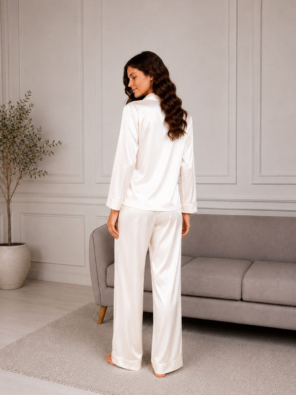 Woman in white pajama set standing in a modern living room.