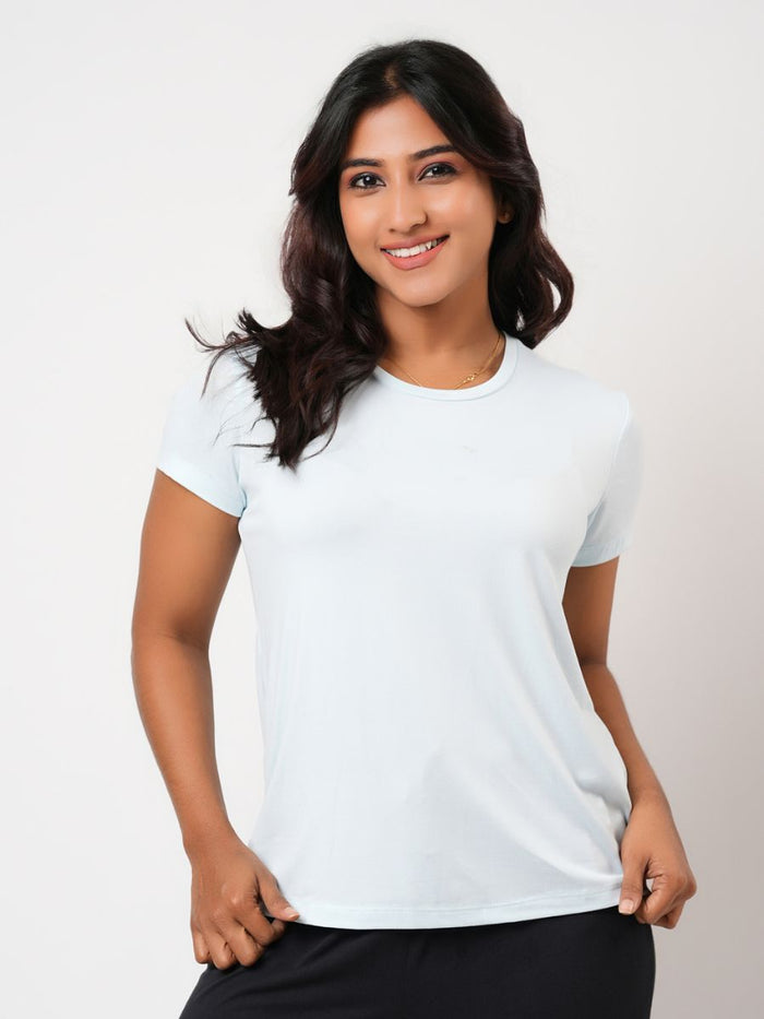 Woman wearing a light blue t-shirt against a plain background