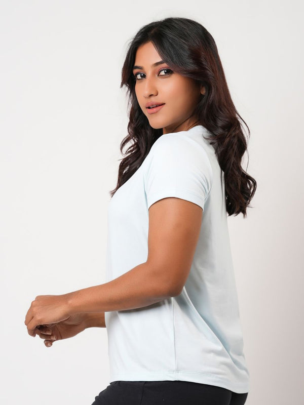 Woman wearing a white t-shirt against a plain background